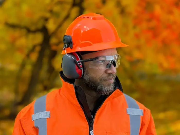 A Man wearing Magna lens earmuff with lens. He is dressed up like he works in a industry.